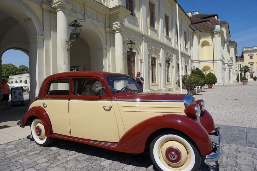 Glänzender Oldtimer im Vordergrund, dahinter die barocke Fassade des Residenzschlosses Ludwigsburg